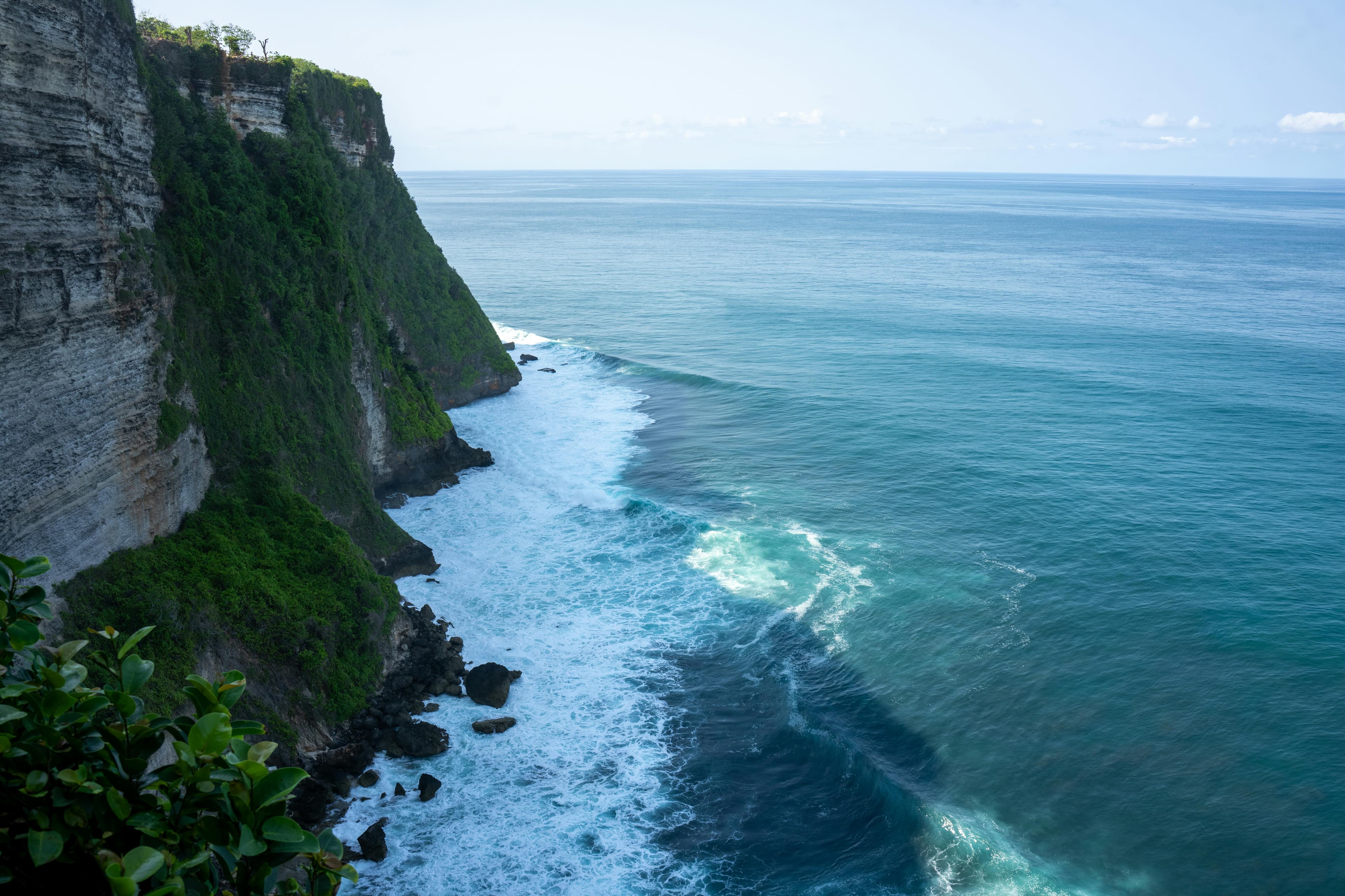 Lush green cliffside meeting a vivid teal ocean, mood imagery for Hair by Beth
